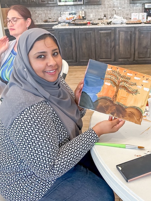 Woman showing her painting during wellness class