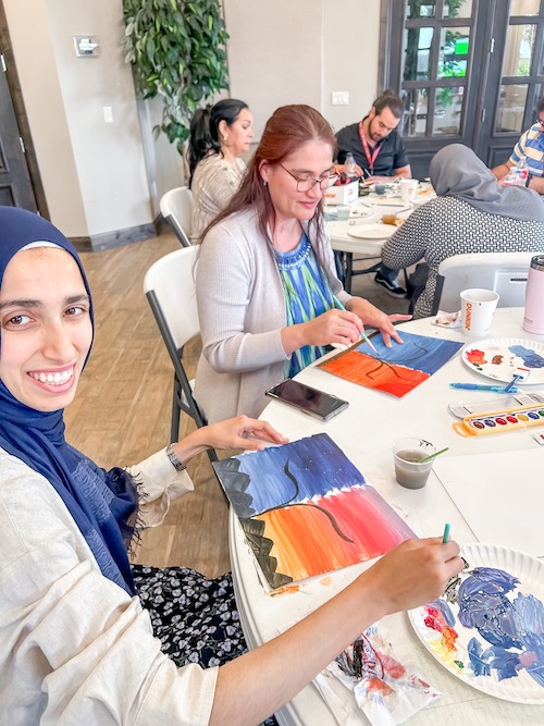 Two woman painting during wellness class