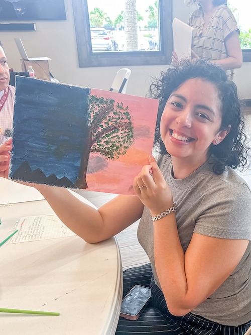 Woman showing her painting during wellness class